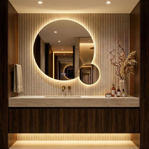 Oglinda Duet, cu diametrul de 90 cm, cu lumina aprinsă, baie cu lamele de travertin, mobilier de nuc, iarbă decorativă