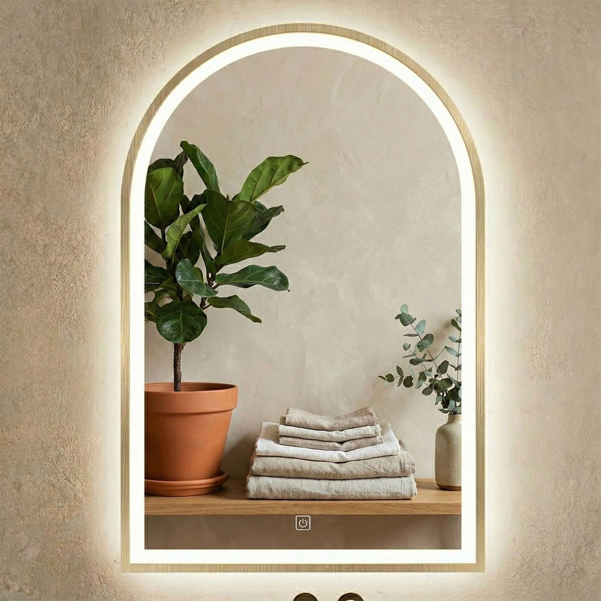 Oglinda Portal în auriu pe tencuială decorativă, deasupra unui raft cu prosoape